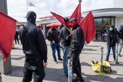 Junge Männer, die die rote Fahne tragen. 1. Mai Demonstration in Hamburg.